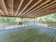 Covered patio features bench seating, wooden floors, and views of the surrounding lush greenery at 525 Turtle Creek Farm Rd, Apex, NC 27523