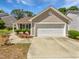 Charming home featuring a two-car garage, well-manicured landscaping, and a beautiful flower bed at 5612 Tealbrook Dr, Raleigh, NC 27610