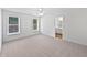A bright main bedroom featuring neutral walls, carpet flooring, a ceiling fan, and a view of the ensuite bath at 5612 Tealbrook Dr, Raleigh, NC 27610