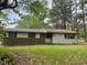 Ranch home with horizontal siding, brick facade, and a mature tree line at 601 Crestview Dr, Durham, NC 27712