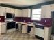 Galley kitchen featuring white cabinets, laminate countertops, and essential appliances at 601 Crestview Dr, Durham, NC 27712