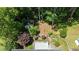 An aerial shot of the house with the backyard deck, shed, and landscaping, nestled among lush trees at 612 Harvest Ln, Raleigh, NC 27606
