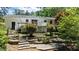 Backyard with white siding, a wooden deck, brick steps, and garden beds with flowering plants at 612 Harvest Ln, Raleigh, NC 27606