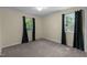 This bedroom features neutral carpeting, a ceiling light, and two windows that provide natural light at 612 Harvest Ln, Raleigh, NC 27606