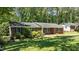 Cozy brick home featuring a neatly kept lawn and mature trees at 612 Harvest Ln, Raleigh, NC 27606