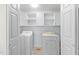 A practical laundry room with white appliances and ample storage cabinets at 612 Harvest Ln, Raleigh, NC 27606