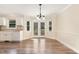 Bright dining room with French doors leading to the backyard, complemented by modern chandelier and laminate flooring at 6225 Jones Farm Rd, Wake Forest, NC 27587