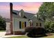 Charming home featuring a brick foundation, vinyl siding, and dormer windows, set against a colorful twilight sky at 6225 Jones Farm Rd, Wake Forest, NC 27587