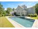 Stunning backyard view of a pool with an attached hot tub, landscaping, and covered patio at 6502 New Market Way, Raleigh, NC 27615