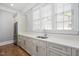 Stylish bar area with white cabinets, sink, quartz countertop, and stainless-steel refrigerator at 6502 New Market Way, Raleigh, NC 27615