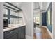 Stylish bar area featuring sleek dark blue cabinetry, mirrored backsplash, and a view of the dining room at 6502 New Market Way, Raleigh, NC 27615