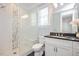 Modern bathroom with white marble tiles, glass shower and stylish vanity at 6502 New Market Way, Raleigh, NC 27615
