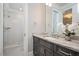 Modern bathroom features a marble countertop, gray cabinetry, and a tiled shower with glass door at 6502 New Market Way, Raleigh, NC 27615