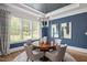 Elegant dining room with a modern chandelier, beautiful blue walls, and a round wood table at 6502 New Market Way, Raleigh, NC 27615