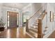 Grand foyer with hardwood floors, elegant staircase, and a stylish chandelier above the front door at 6502 New Market Way, Raleigh, NC 27615