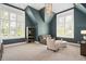 Cozy living room has a dark green accent wall, two large windows and modern furniture at 6502 New Market Way, Raleigh, NC 27615