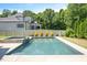 Sparkling pool with integrated hot tub and manicured shrubs, complemented by the backyard privacy fence at 6502 New Market Way, Raleigh, NC 27615