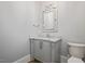 Elegant powder room featuring a gray vanity with marble countertop and decorative mirror at 6502 New Market Way, Raleigh, NC 27615