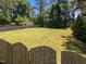 Large fenced yard with mature trees, lush grass, and a storage shed at 6513 Cablewood Dr, Raleigh, NC 27603