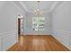 Traditional dining room featuring hardwood floors, large window, beautiful chandelier and wainscotting at 6513 Cablewood Dr, Raleigh, NC 27603