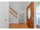Bright entryway featuring hardwood floors, stairs with wood railing and leaded glass front door at 6513 Cablewood Dr, Raleigh, NC 27603