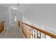 Upstairs hallway with a wood railing overlooking the living area at 6513 Cablewood Dr, Raleigh, NC 27603