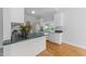 Bright kitchen featuring white cabinetry, wood floors, and a view from the window over the kitchen sink at 6513 Cablewood Dr, Raleigh, NC 27603