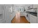 Bright kitchen featuring white cabinets, a bay window above the sink, and wooden flooring at 6513 Cablewood Dr, Raleigh, NC 27603