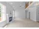 Large, bright living room with a fireplace and large windows. Also features a stairway to a second level at 6513 Cablewood Dr, Raleigh, NC 27603