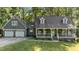 Charming home with a welcoming front porch and two-car garage nestled among lush greenery at 6517 Hidden Pond Rd, Wendell, NC 27591