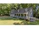 Charming home with a welcoming front porch and two-car garage nestled among lush greenery at 6517 Hidden Pond Rd, Wendell, NC 27591