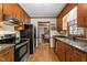 Traditional-style kitchen with wood cabinets, stainless appliances, and granite counters at 6517 Hidden Pond Rd, Wendell, NC 27591