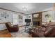 Inviting living room with a brick fireplace, hardwood floors, and natural light from large windows at 6517 Hidden Pond Rd, Wendell, NC 27591