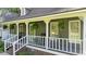 Inviting front porch with rocking chairs, white railing, and charming hanging plants at 6517 Hidden Pond Rd, Wendell, NC 27591
