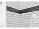 Modern bathroom shower featuring white subway tiles with a stylish accent at 6565 New Market Way, Raleigh, NC 27615