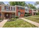Traditional brick townhomes showcasing well-manicured lawns and charming curb appeal with colorful flowerbeds at 6565 New Market Way, Raleigh, NC 27615
