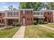 Traditional brick townhomes showcasing well-manicured lawns and charming curb appeal with colorful flowerbeds at 6565 New Market Way, Raleigh, NC 27615