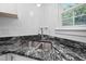 Close up of a stainless steel sink with granite countertops and a window view at 6565 New Market Way, Raleigh, NC 27615