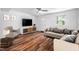 Staged living room featuring a sofa, modern entertainment center and new hardwood floors at 6565 New Market Way, Raleigh, NC 27615
