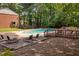 Community pool with plenty of lounge chairs, deck, and wooded area behind at 6565 New Market Way, Raleigh, NC 27615