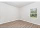 View of empty bedroom with wood-look flooring and natural light from a window at 680 Winesap Dr, Graham, NC 27253