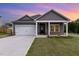 Charming home with gray siding, white trim, a two-car garage, and a manicured front yard at 680 Winesap Dr, Graham, NC 27253