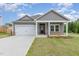 Charming home with gray siding, white trim, a two-car garage, and a manicured front yard at 680 Winesap Dr, Graham, NC 27253