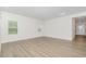 Bright living room with light wood floors, white walls, and multiple windows with blinds at 680 Winesap Dr, Graham, NC 27253