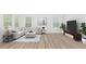 Cozy living room featuring neutral furnishings, wood-look flooring, and ample natural light at 680 Winesap Dr, Graham, NC 27253
