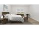 Comfortable main bedroom with a woven headboard, bench, natural light, and neutral decor at 680 Winesap Dr, Graham, NC 27253
