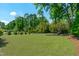 Spacious, well-maintained backyard, partially fenced in and with mature trees at 702 Wimbleton Dr, Raleigh, NC 27609