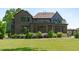 Back view of the house and patio area with lush landscaping and sprawling lawn at 702 Wimbleton Dr, Raleigh, NC 27609