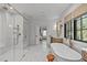 Luxurious bathroom with soaking tub, walk-in shower, and views to the bedroom and outdoors at 702 Wimbleton Dr, Raleigh, NC 27609