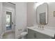 Elegant powder room featuring stylish herringbone accent wall, framed mirror, and designer fixtures at 702 Wimbleton Dr, Raleigh, NC 27609